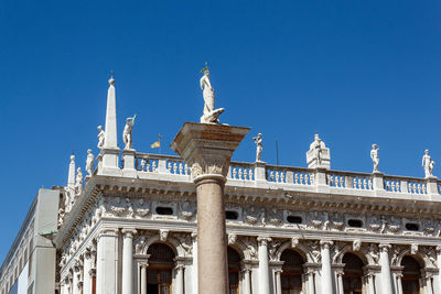 Low angle view of statue against blue sky