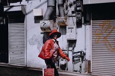 Rear view of woman standing by building