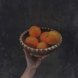 Close-up of hand holding fruits in bowl