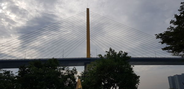 Low angle view of suspension bridge against sky
