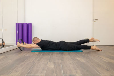 Male fitness pilates trainer shows exercises on special simulators. rubber rings for stretching