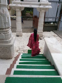 High angle view of woman moving down on steps at temple