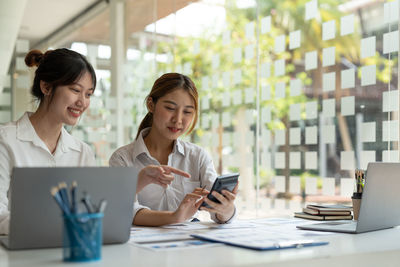 Smiling businesswomen brainstorming at office