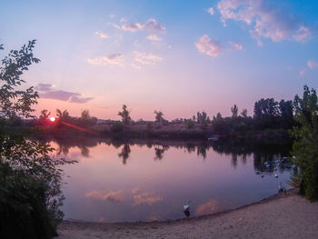 Scenic view of lake against sky at sunset