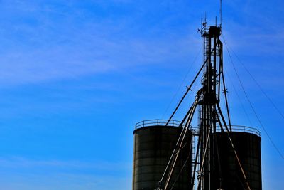 Low angle view of crane against blue sky