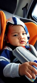 Portrait of cute baby boy in car