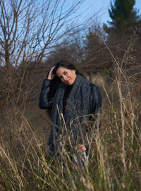 A woman in a smiling attitude through the dry grass