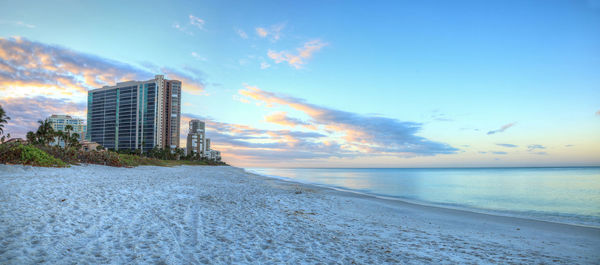 Scenic view of sea by buildings against sky