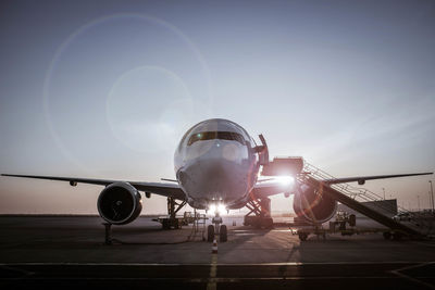 Low angle view of airplane at airport runway against sky