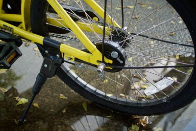 Cropped image of bicycle wheel on wet road