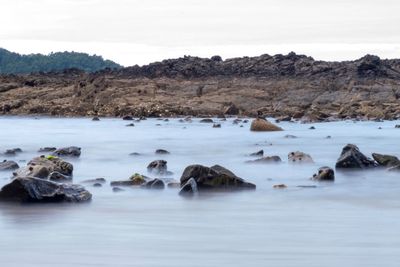 Rocks in sea against sky