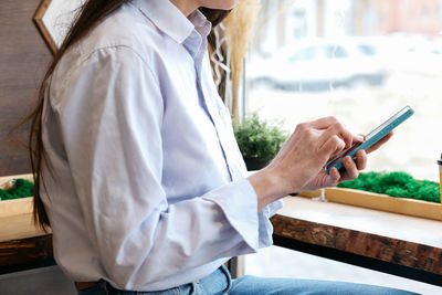 Midsection of woman using mobile phone