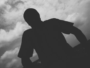 Silhouette of person against cloudy sky