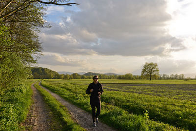 Rear view of man walking in field