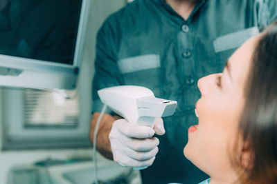 Midsection of dentist examining patient teeth