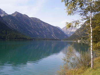 Calm lake against mountain range