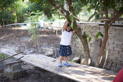 Full length of woman standing against trees