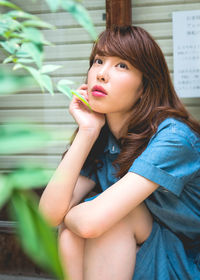 Portrait of beautiful young woman sitting outdoors