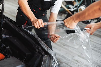 People removing plastic from car