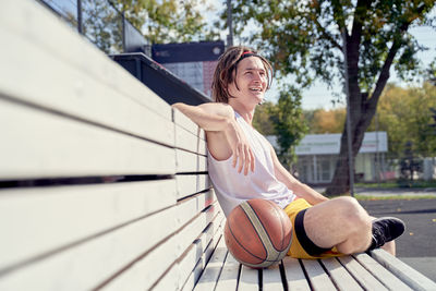 Portrait of smiling young woman exercising on field