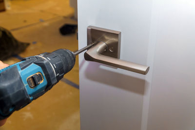 Close-up of drill fixing doorknob