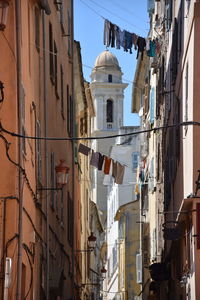 Low angle view of clothes hanging amidst buildings in city