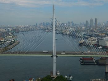 Bridge over river against cloudy sky