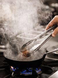 Chef preparing steak in kitchen.