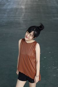 High angle view of young woman with eyes closed standing on road