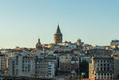 Buildings in city against clear sky