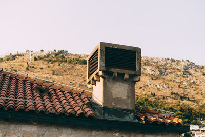 Old house roof against clear sky