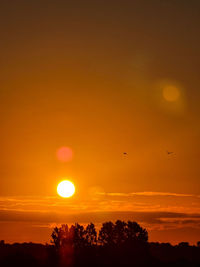 Low angle view of silhouette trees against romantic sky at sunset