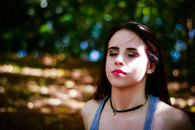 Close-up of young woman with eyes closed at park