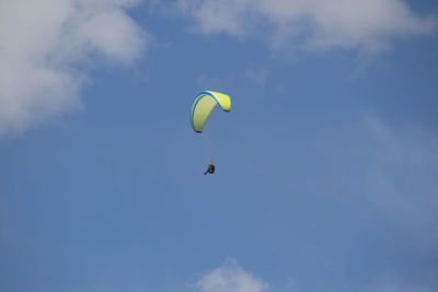 Low angle view of person paragliding against sky