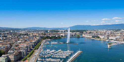 High angle view of city buildings against blue sky