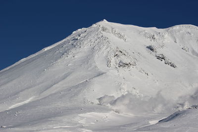 Scenic view of snowcapped mountains against clear blue sky