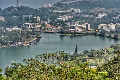 Scenic view of river by city against sky