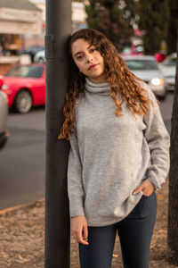 Portrait of young woman standing in car