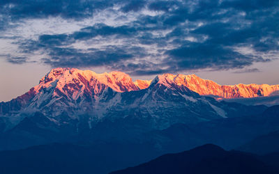 Scenic view of snowcapped mountains against sky during sunset