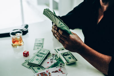 Midsection of man playing cards at table