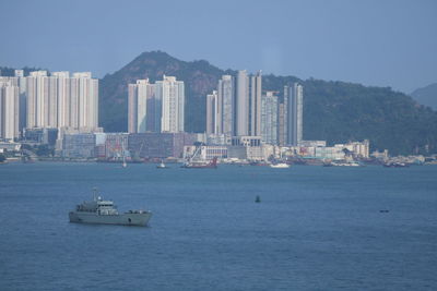 Boats in sea against buildings in city