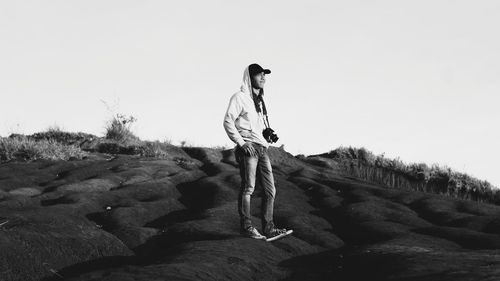 Woman standing on rock against sky