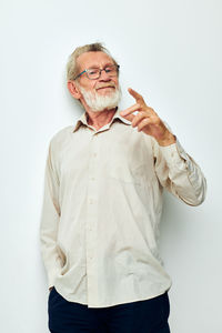 Senior man gesturing against white background