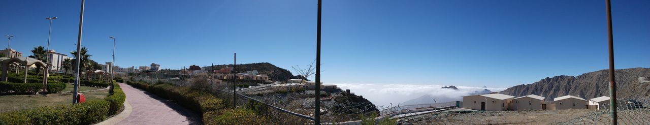 Panoramic view of buildings against clear blue sky