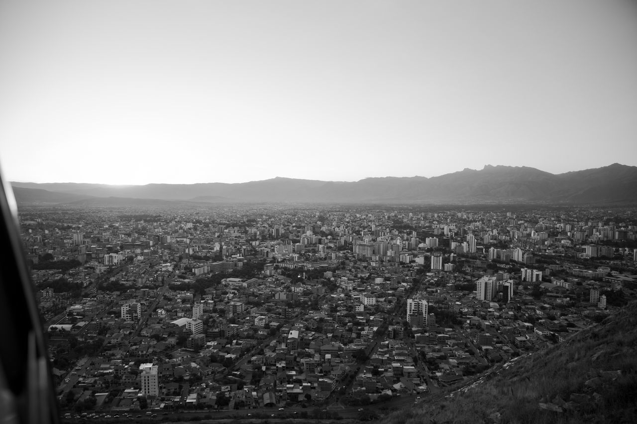 HIGH ANGLE VIEW OF CITYSCAPE AGAINST MOUNTAINS