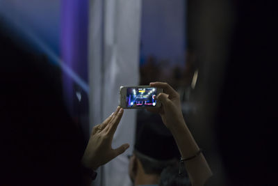 Cropped hands of young woman photographing with mobile phone