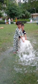 Rear view of people standing in water