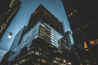 Low angle view of illuminated buildings against sky at night