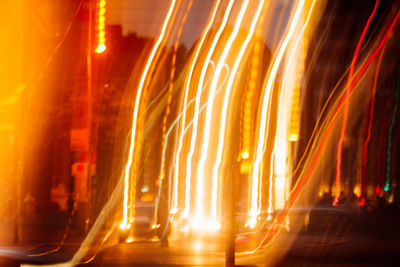 Light trails on road by buildings at night