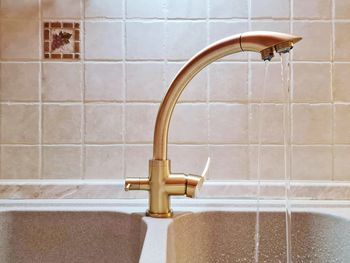 Three-way bronze colored faucet connected to a purifier